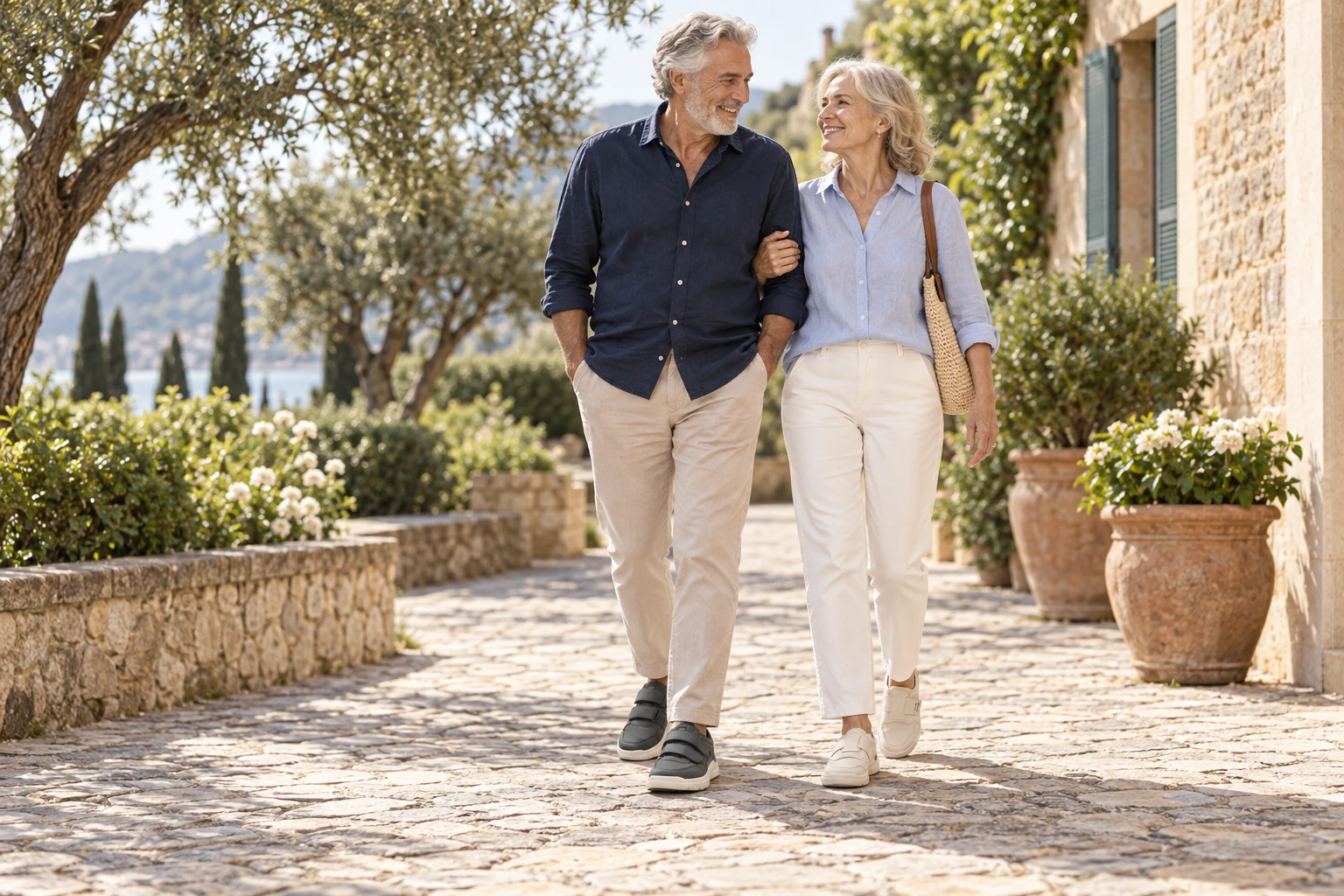 Una coppia matura passeggia in giardino indossando scarpe FitStory grigie e crema con chiusura a strappo